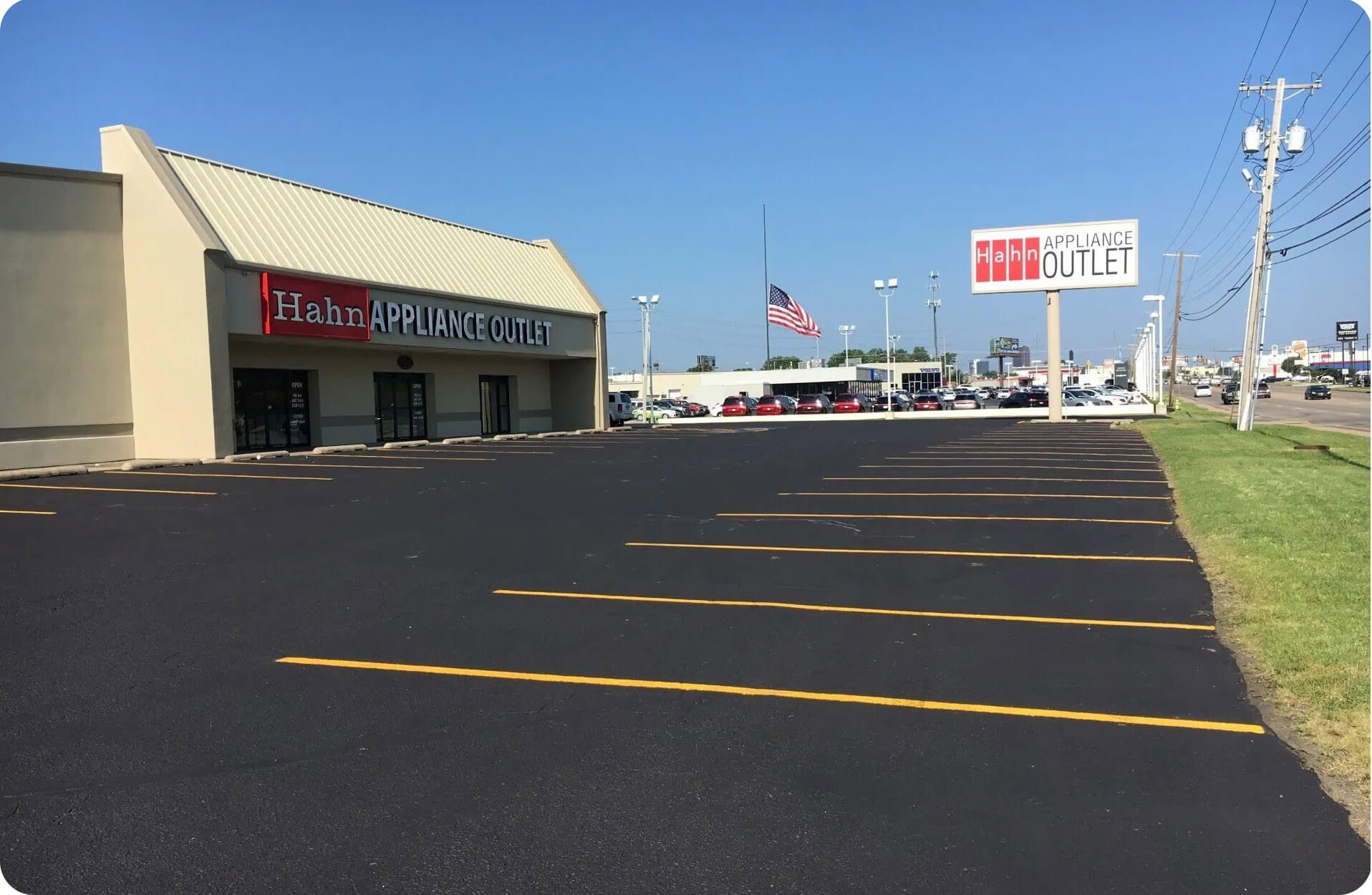 New Asphalt Parking Lot at Hahn Appliance Outlet Freshly paved asphalt parking lot at Hahn Appliance Outlet with clear parking lines and American flag in the background